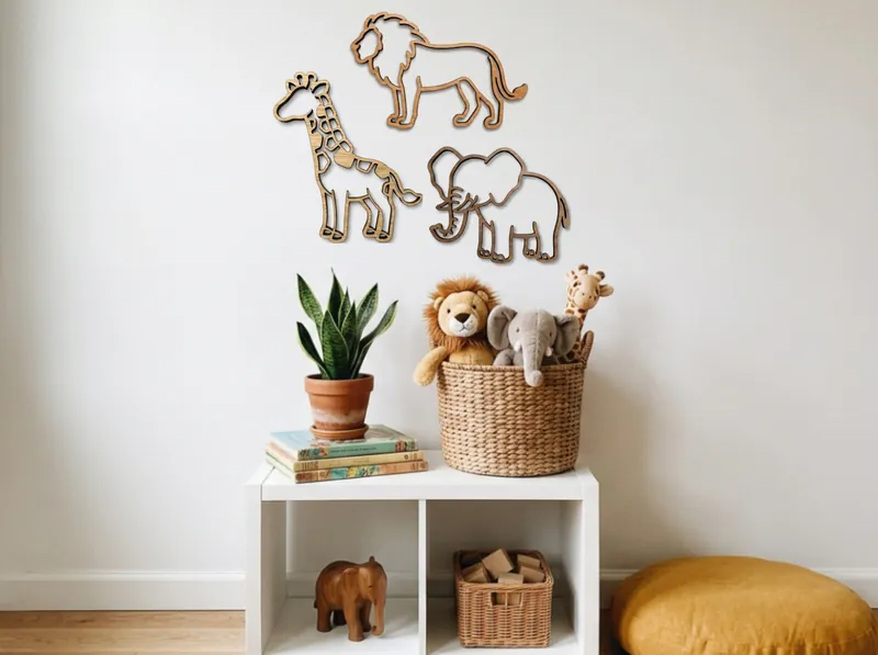 Wooden lion, elephant and giraffe on a nursery wall above a toy shelf